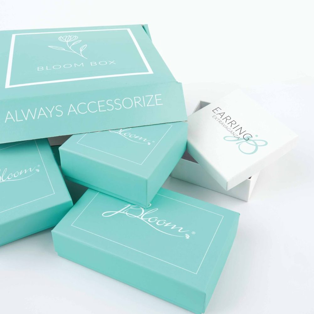 The jBloom Bloom Box and Earring of the Month subscription boxes stacked together